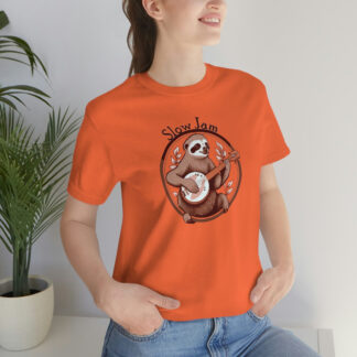 A woman wearing an orange banjo shirt with a cute sloth sitting within a circular frame adorned with leaves playing the banjo with the words "Slow Jam" above.