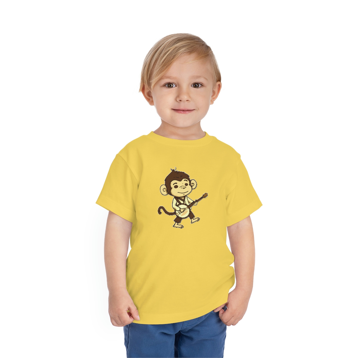 A little boy wearing a yellow banjo shirt with a cute, brown cartoon monkey holding a banjo while walking.